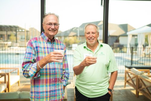 two men smiling having a drink