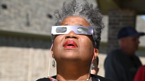 woman watching solar eclipse with protective glasses