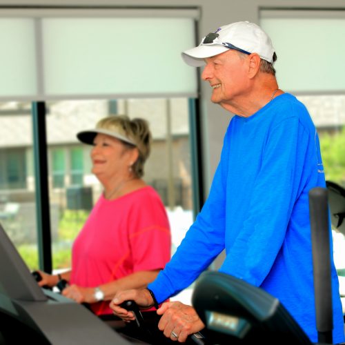 man and woman walking on treadmills