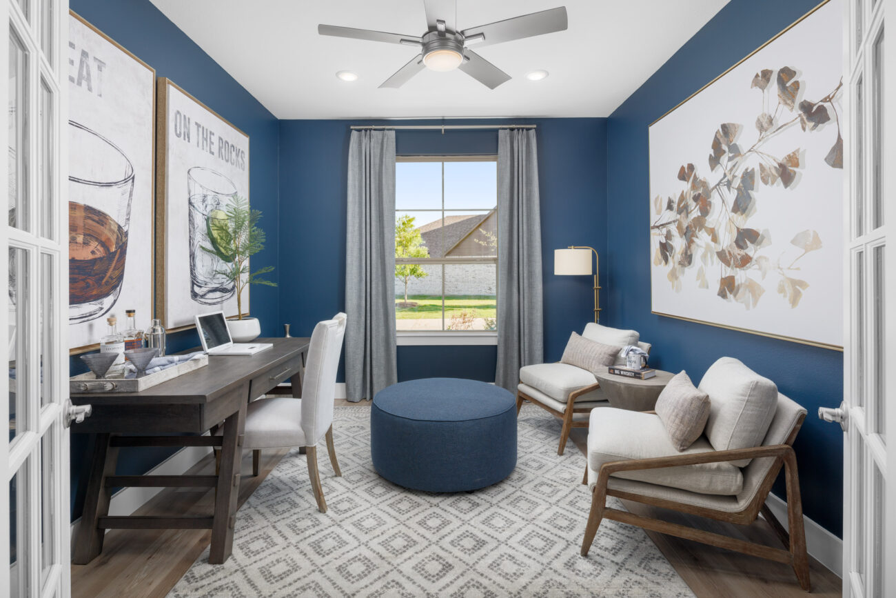 Stylish home office at Ladera Living with navy walls, natural light, modern decor, and cozy seating for work or relaxation