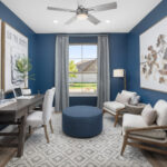 Stylish home office at Ladera Living with navy walls, natural light, modern decor, and cozy seating for work or relaxation