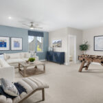 Spacious living room with sectional sofa, foosball table, and modern decor at Ladera Living community