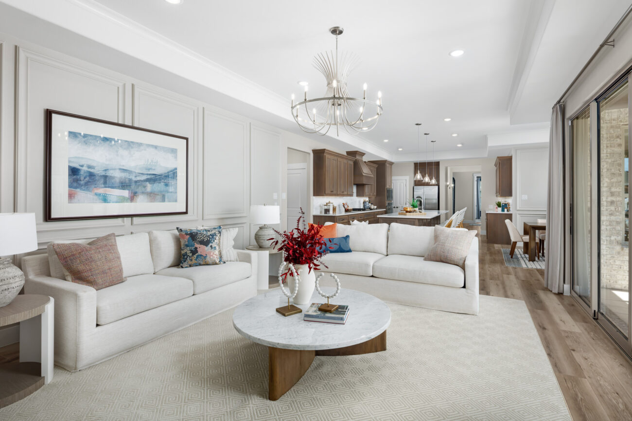 Open-concept living room and kitchen with elegant decor, neutral tones, and natural light at Ladera Living