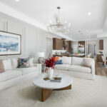Open-concept living room and kitchen with elegant decor, neutral tones, and natural light at Ladera Living