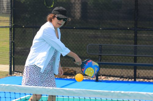 woman backhanding a pickleball