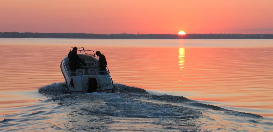 small boat on lake at sunset