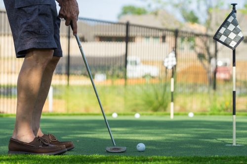 man putting a golf ball