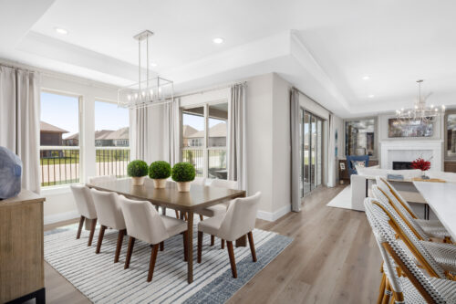Elegant dining area at Ladera Living with natural light, modern decor, plush seating, and views of the backyard patio