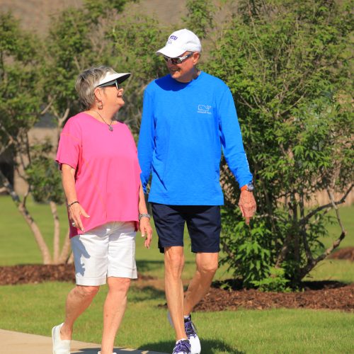 couple holding hands walking on trail