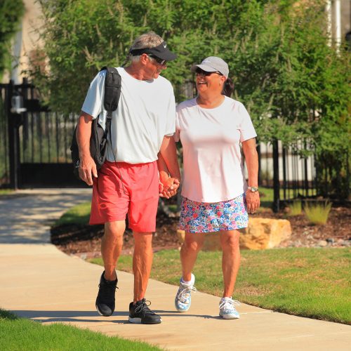 couple holding hands walking on trail