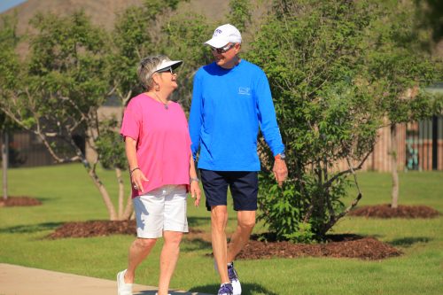 couple holding hands walking on trail