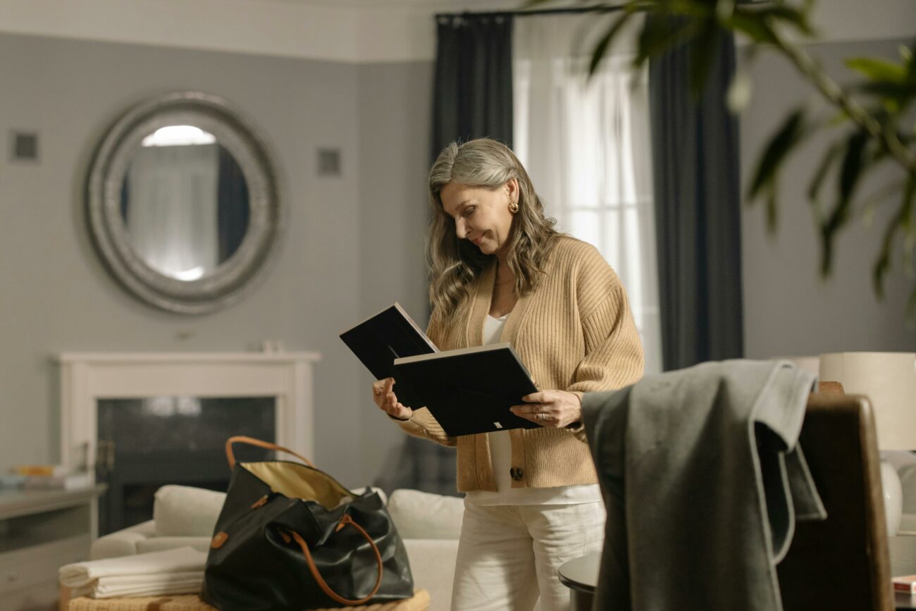 Senior woman looking at photo frames while packing to move -Downsizing/Rightsizing Seminars