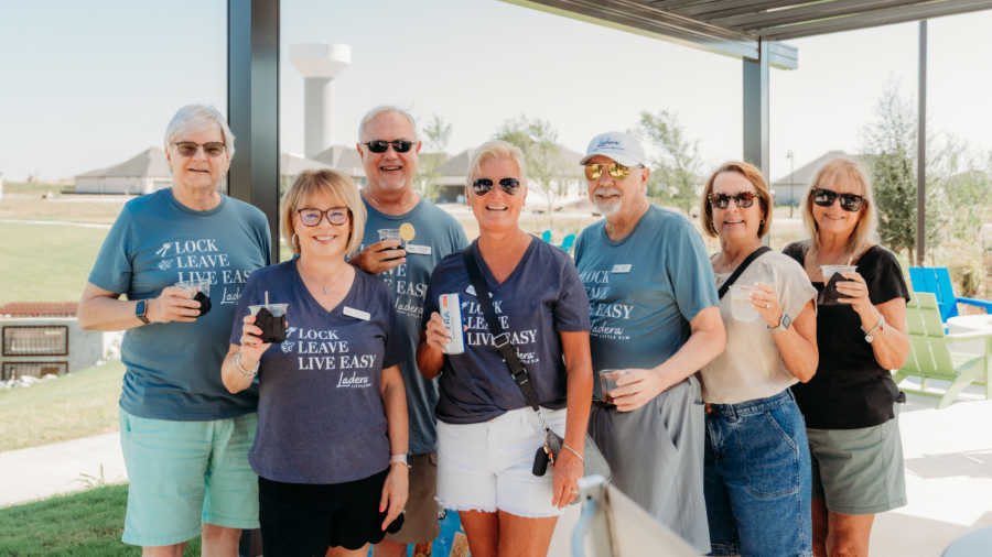 A group of 55+ homeowners smile and pose together at The HUB in a Ladera Living 55+ community
